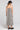 Back view of a woman wearing the Saltwater Luxe Marcelia Black Midi Dress on a neutral background
