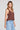 Side angle view of a woman wearing the Saltwater Luxe Marlie Coffee Tank on a neutral background