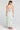 Back view of a woman wearing the Saltwater Luxe Medina Midi Dress in Pearl on a neutral background