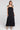 Front view of a woman wearing the Saltwater Luxe Melia Black Maxi Dress on a neutral background