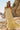 Front view of a woman wearing the Saltwater Luxe Melia Sunglow Maxi Dress on the beach