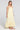 Side angle view of a woman wearing the Saltwater Luxe Melia Sunglow Maxi Dress on a neutral background