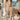 Full body front view of a woman wearing the Saltwater Luxe Millie Oatmeal Pant beside a chair 