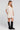 Side angle view of a woman wearing the Saltwater Luxe Nicko Natural Mini Dress on a neutral background