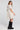 Back view of a woman wearing the Saltwater Luxe Nicko Natural Mini Dress on a neutral background