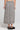 Back view of a woman wearing the Saltwater Luxe Nolla Midi Skirt on a neutral background