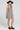 Side angle view of a woman wearing the Saltwater Luxe Pettra Mini Dress on a neutral background