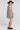 Back view of a woman wearing the Saltwater Luxe Pettra Mini Dress on a neutral background