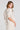 Back view of a woman wearing the Saltwater Luxe Preslee Top on a neutral background