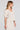 Side angle view of a woman wearing the Saltwater Luxe Preslee Top on a neutral background