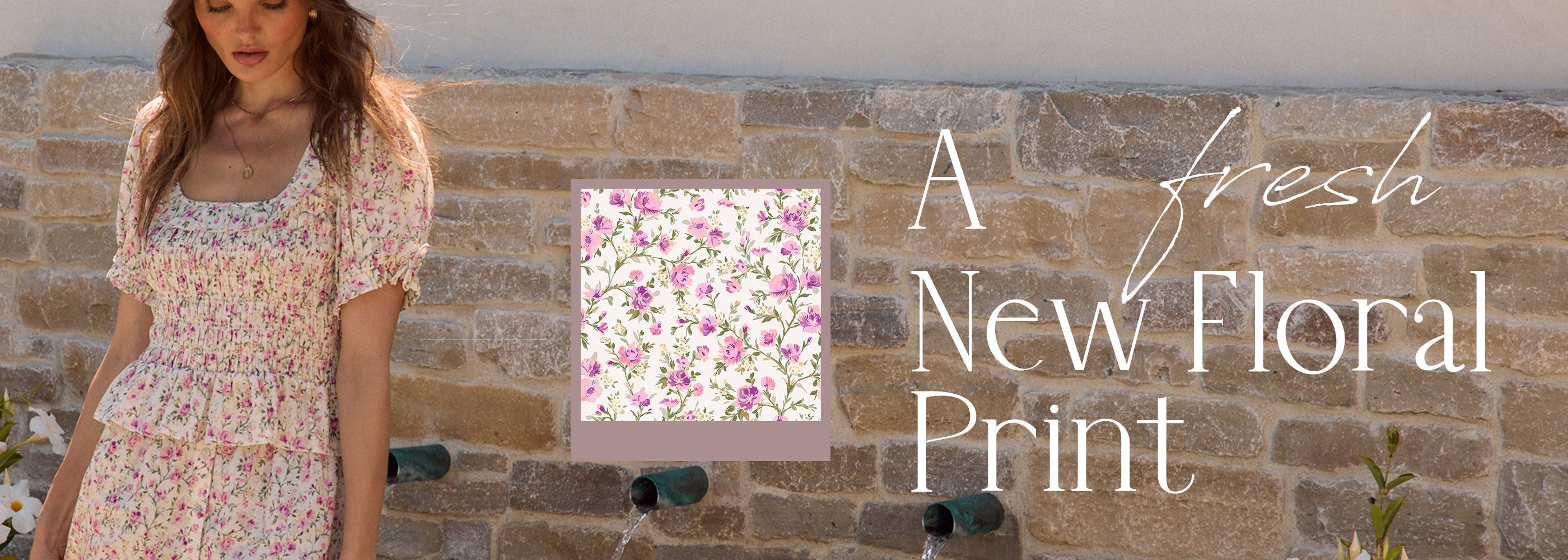 Woman wearing a floral dress standing against a stone wall with a floral print inset and text
