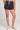 Front view of a woman wearing the Saltwater Luxe Pull On Black Shorts on a neutral background