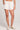 Front view of a woman wearing the Saltwater Luxe Pull On Ecru Shorts on a neutral background
