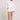 Full body front view of a woman wearing the Saltwater Luxe Pull On Ecru Shorts on a neutral background