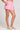 Side angle view of a woman wearing the Saltwater Luxe Pull On Petunia Shorts on a neutral background