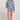 Full body front view of a woman wearing the Saltwater Luxe Pull On Worn Blue Shorts on a neutral background