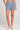 Front view of a woman wearing the Saltwater Luxe Pull On Worn Blue Shorts on a neutral background