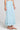 Side angle view of a woman wearing the Saltwater Luxe  Rainer Midi Skirt in Azure Blue on a neutral background