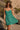 Front view of a woman wearing the Saltwater Luxe Renoa Mini Dress on a rocky beach