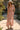 Full body front view of a woman wearing the Saltwater Luxe Rommie Multicolored Midi Skirt in a garden