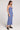 Side view of woman wearing the Saltwater Luxe blue Cannan Midi Dress with a slit on a plain background