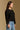 Model wearing the Saltwater Luxe Charmer Black Sweater with scattered metallic embellishments, side view