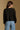 Model wearing the Saltwater Luxe Charmer Black Sweater with scattered metallic embellishments, back view