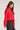 Side view of woman wearing the Saltwater Luxe Charmer red Sweater with white heart patterns on a plain background