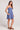 Full body side view of a woman wearing the blue Saltwater Luxe Jazmyn Mini Dress against a plain background