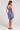 Full body back view of a woman wearing the blue Saltwater Luxe Jazmyn Mini Dress against a plain background