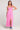 Front full body view of a woman wearing the Saltwater Luxe pink Hayley Midi Dress with a slit on a plain background