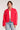 Front view of woman wearing the Saltwater Luxe Brenwood Jacket in Vintage Red with white accents layered over a white shirt and blue jeans on a light gray background