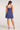 Back view of woman wearing the Saltwater Luxe Arwen Mini Dress in Blue featuring a 3/4 zip-up back on a white background