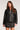 Front view of woman wearing the Saltwater Luxe Vespera black faux leather jacket, zipped up,  on a plain background
