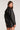 Back view of woman wearing the Saltwater Luxe Vespera black faux leather jacket on a plain backdrop