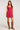 Front view of woman wearing the Saltwater Luxe red Pipper Scarlet Mini Dress with brown knee-high boots on a white background