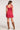 Back view of woman wearing the Saltwater Luxe red Pipper Scarlet Mini Dress with brown knee-high boots on a white background