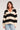 Front view of woman wearing the Saltwater Luxe Emberr Sweater in stone with bold black horizontal stripes and a collared V-neck design on a white background