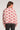 Back view of woman wearing the Saltwater Luxe Lionna Scarlet Sweater in pink with heart pattern on a white background