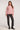 Full body view of woman wearing the Saltwater Luxe Lionna Scarlet Sweater in pink with heart pattern and black jeans on a white background