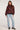Full body view of woman wearing the Saltwater Luxe Lionna Black Sweater with red floral patterns and light blue jeans on a white background