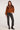 Full body view of woman wearing the Saltwater Luxe brown Orson Sweater with patterned shoulders and black jeans against a white background