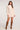 Full body front view of woman wearing the Saltwater Luxe Brianah Sweater Dress in pearl white with a mock turtleneck and brown knee-high boots on a white background