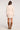 Full body back view of woman wearing the Saltwater Luxe Brianah Sweater Dress in pearl white with a mock turtleneck and brown knee-high boots on a white backdrop