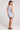 Back view of a woman wearing the Saltwater Luxe light blue Enya Skyline Mini Dress on a plain background