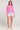 Full boduy view of a woman wearing the Saltwater Luxe pink Amorette Magnolia Sweater and denim shorts on a plain background
