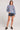 Full body view of the Saltwater Luxe Ronnie Sweater in Dusty Blue styled with black denim shorts and black platform sandals on a white background