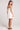 Back view of a woman wearing the Saltwater Luxe Augustina Salt White Mini Dress on a plain background