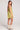 Back view of woman wearing the Saltwater Luxe Augustina Willow Green Mini Dress with white cowboy boots on a plain background