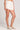 Side view of a woman wearing the Saltwater Luxe Arabella salt white shorts on a plain background